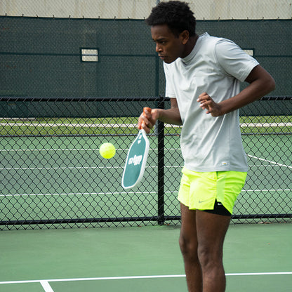 African American Male using Dilly Co Fiberglass Paddle to hit a dink shot